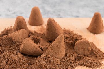 Production of chocolate truffles - sprinkle of chocolates with cocoa powder.