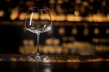 Empty wine glass standing on the bar counter