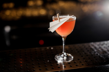 Elegant decorated glass filled with fresh Paper Plane cocktail