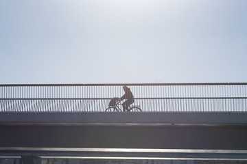 Naklejka premium a man cycling on a bridge
