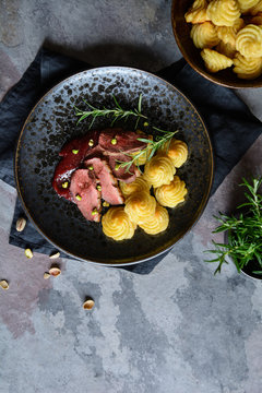 Duck breasts with Pommes Duchesse, cranberry sauce and pistachios