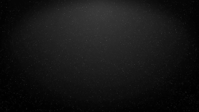 Little particles of dust, stardust or micro parts flying and moving on the black and gray background.