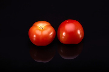 Fresh tomatoes on black background.