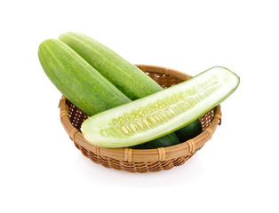 whole and half cut fresh cucumbers in bamboo basket on white background
