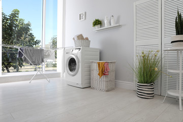 Laundry room interior with washing machine near wall