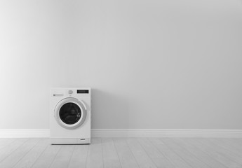 Washing machine near white wall, space for text. Laundry day
