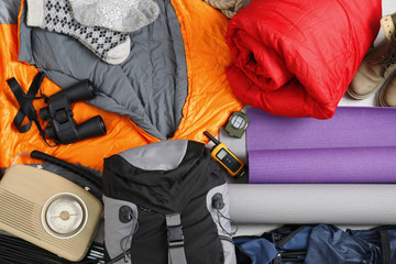 Composition with sleeping bags and camping equipment as background