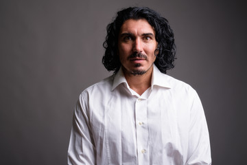 Handsome businessman with mustache against gray background