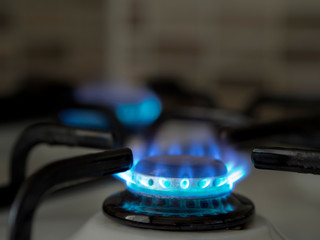 left open oven gas in the home kitchen. close-up blue colored burning gas