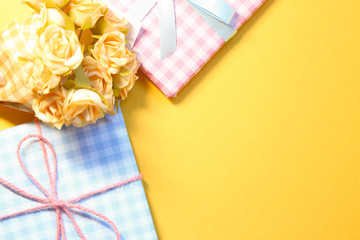 Check pattern colorful gift boxes with flower bouquet on yellow background