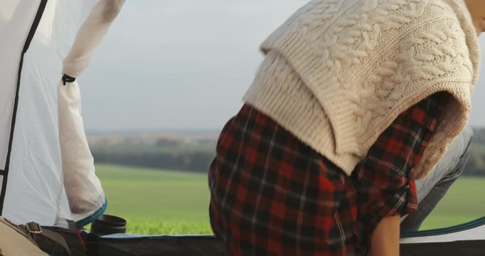 Camping woman lying in tent . Close up of girl relaxing on vacation. Young happy female caucasian model puting backpack in tent 4k video View from inside