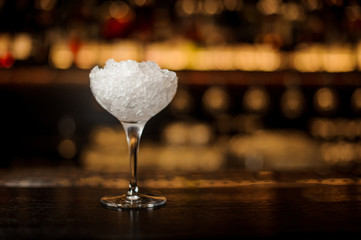 Glass of crushed ice standing on the bar counter