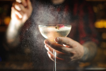 Professional bartender spraying on the delicious Twinkle cocktail in the bar