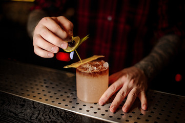 Bartender adding to a delicious Mai Tai cocktail lime slice and berry