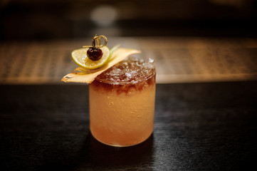 Delicious Mai Tai cocktail with dried pineapple, lime slice and red berry