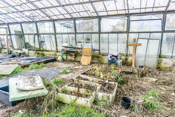 Demolished Greenhouse with wooden cross