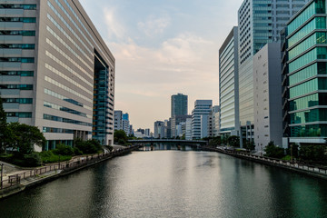 Obraz premium High rise office buildings, either side of a river cutting through the city