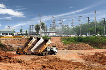 Land reclamation for solar power plants and biomass power plants with tractor and dump trucks.