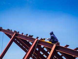 The Welder man a welding the steel roof, worker with unprotected and unsafely, Electric iron oxide.