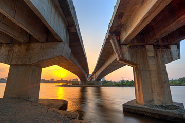 A long exposure picture of beautiful burning sunset and blue hour  under the bridge
