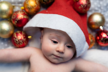 Obraz na płótnie Canvas Cute tiny baby wearing a Christmas Santa hat