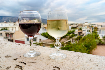 Wine glasses on a rooftop in Athens, Greece with a view of the city beyond. Concept of romantic traveling adventures.