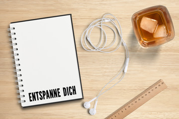 Ringbuch mit Nachricht "Entspanne Dich" und ein Drink mit Eiswürfeln