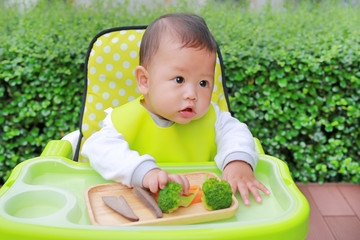 Asian infant baby boy eating by Baby Led Weaning (BLW). Finger foods concept.
