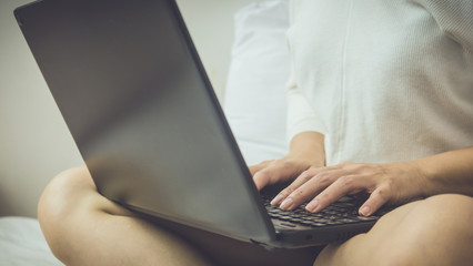 Beautiful woman lying in bed with a laptop