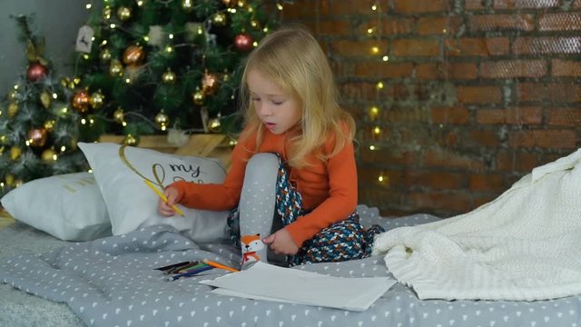 Little Girl Draw Near the Christmas Tree