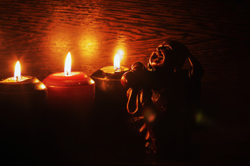 burning candles and a statue on a black background - Powered by Adobe