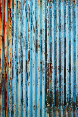 塗装が剥げた古い波鉄板のフェンス