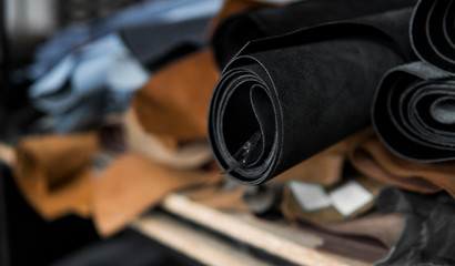 Different pieces of leather in a rolls. The pieces of the colored leathers. Rolls of natural brown...