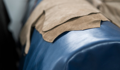 Different pieces of leather. The pieces of the colored leathers. Natural blue ang light brown leather. Raw materials for manufacture of bags, shoes, clothing and accessories.