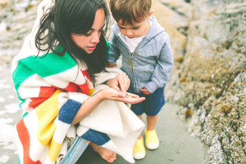 a mother and son exploring on the beach - Powered by Adobe