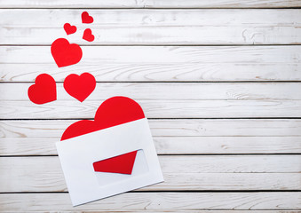 Red hearts in a white envelope. Correspondence of people in love. Paper hearts cut from paper. Valentine's Day.