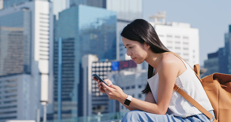 Woman look at mobile phone in city