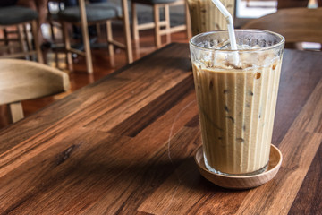 Coffee glass on the wooden floor with blur background.
