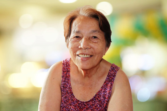 Portrait of asian elderly woman smiling with colorful bokeh background, Happy and good mood concept