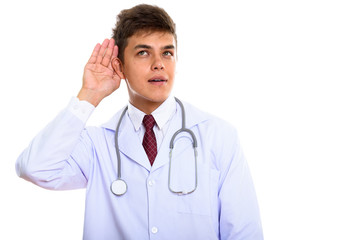 Studio shot of young handsome man doctor listening