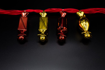 Red and golden christmas decorations on black background.
