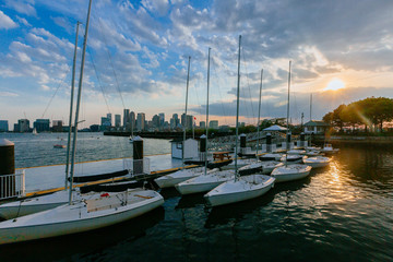 Fototapeta na wymiar Sail boats with skyline of downtown Boston at sunset, in Boston, MA, USA