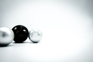 Black and silver Christmas baubles on white background.