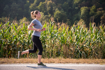 woman jogging along a country road