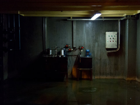 Industrial basement with wet floor. Dark gloomy ambient terror movie concept 