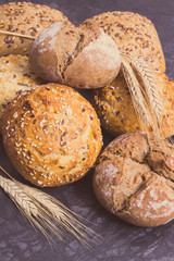 Rolls or bread with seeds and ears of rye grain. Vintage photo