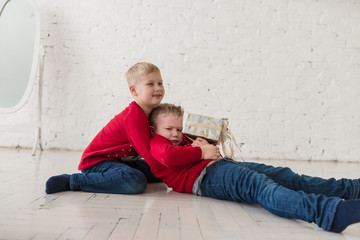 Emotional boys play on the floor at white room in christmas