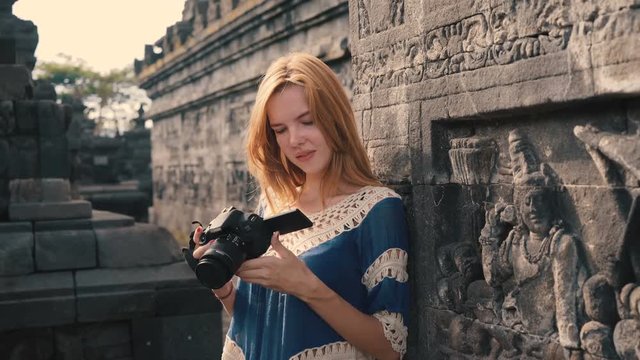 Young caucasian woman looking at camera while standing on middle level of Borobudur temple in Java, Indonesia