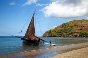 An old sailing ship stands off the coast of Nosy Be Island