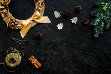 Process of making christmas wreath concept. Creative christmas wreath made of thread near matherials and instruments, sciccors on black background top view copy space